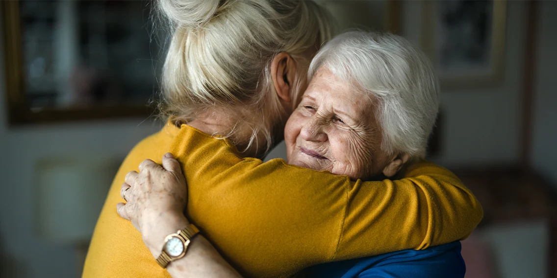 a woman giving a warm hug to parent