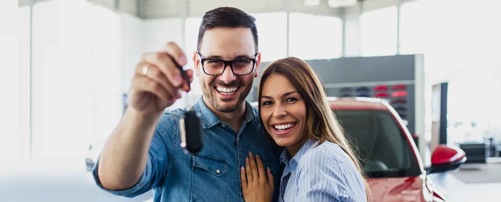 Happy couple smiling and looking at the phone screen