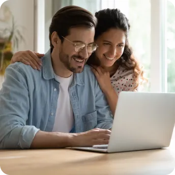 couple looking at computer screen and smiling