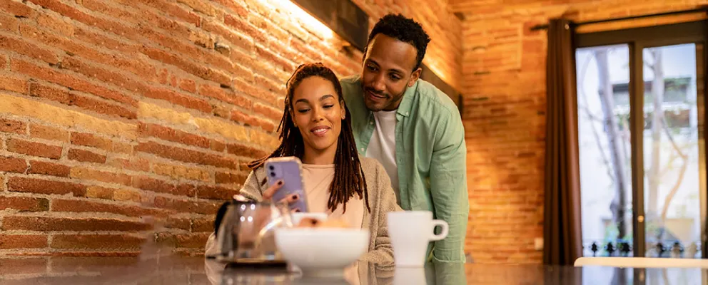 man and woman looking at the phone