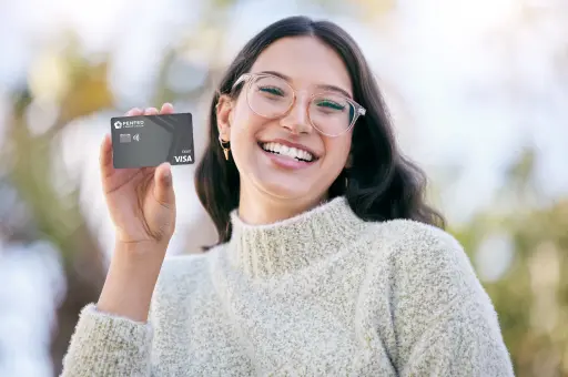 a girl holding a card in her hand and smiling