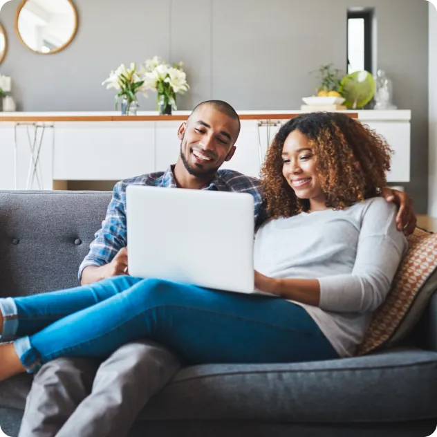 Couple on the couch viewing laptop