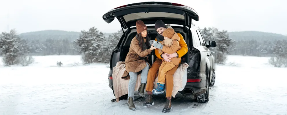 family sitting in a car trunk