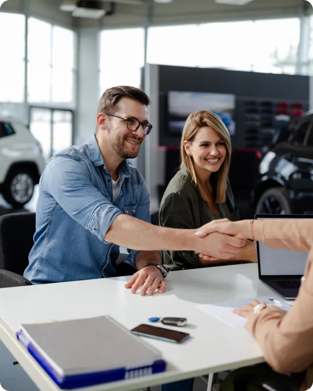 couple successfully purchasing a car at a dealership