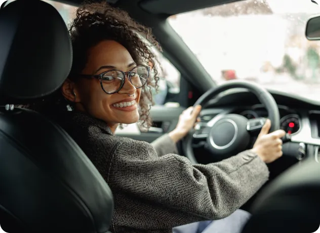 a smiling girl sitting in front seat of car