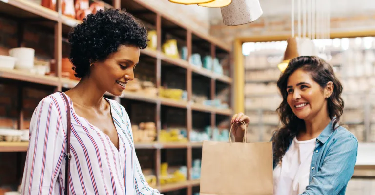 Woman handed a shopping bag at a store