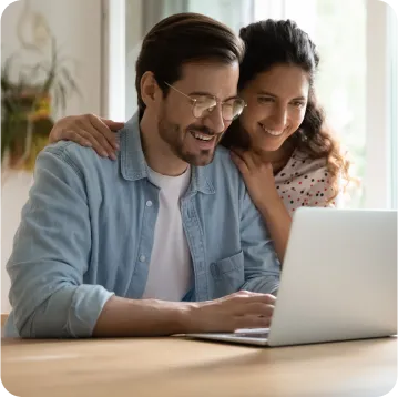 A couple looking at the laptop smiling