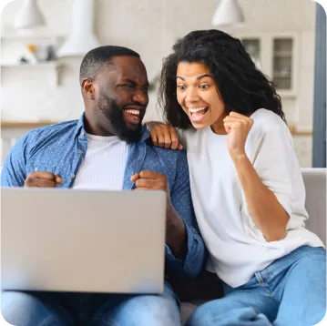 An excited couple looking at the laptop