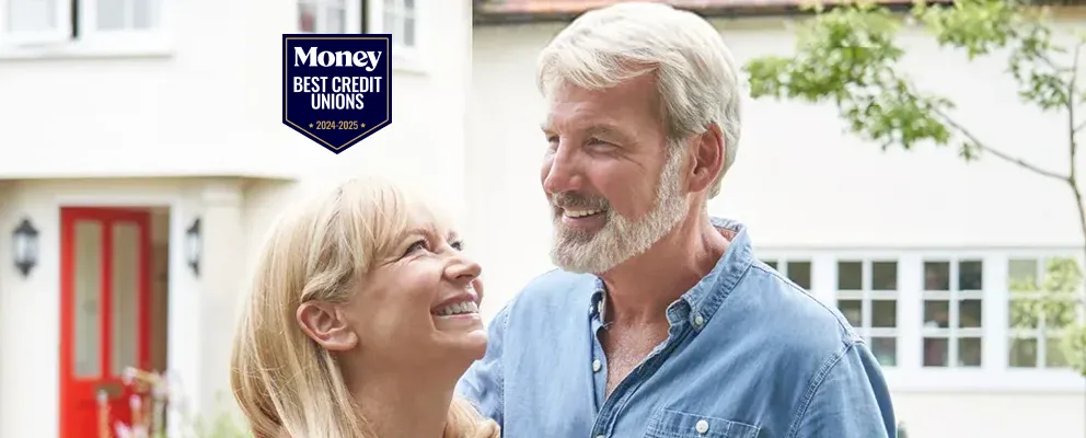 smiling couple in front of their new home