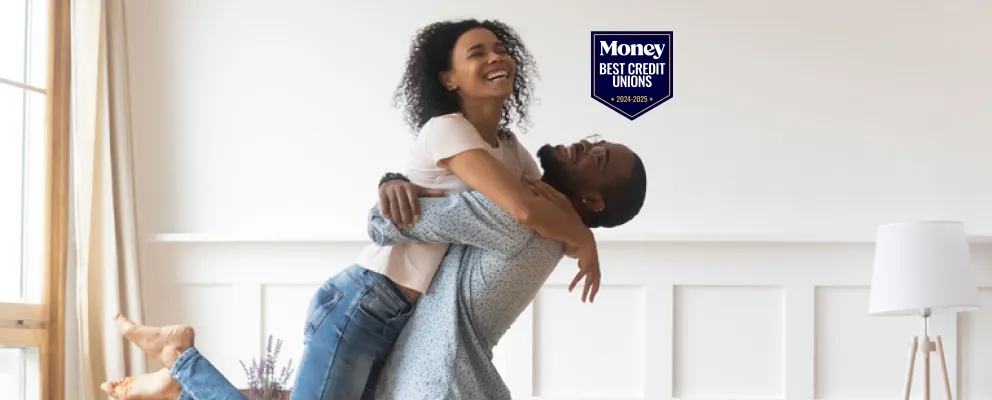 couple cheering in their living room of their newly purchased home